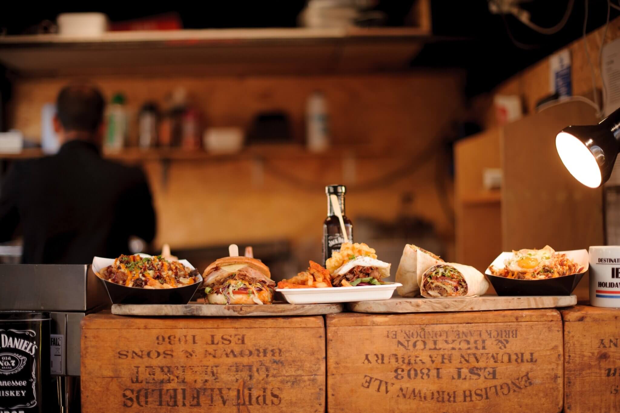 Street food dishes served on wooden crates at a catering pod