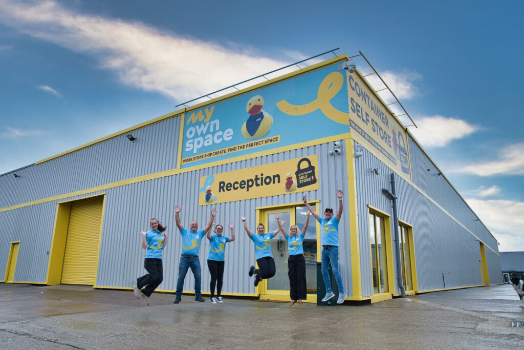 The team jumping outside the My Own Space branded facility entrance