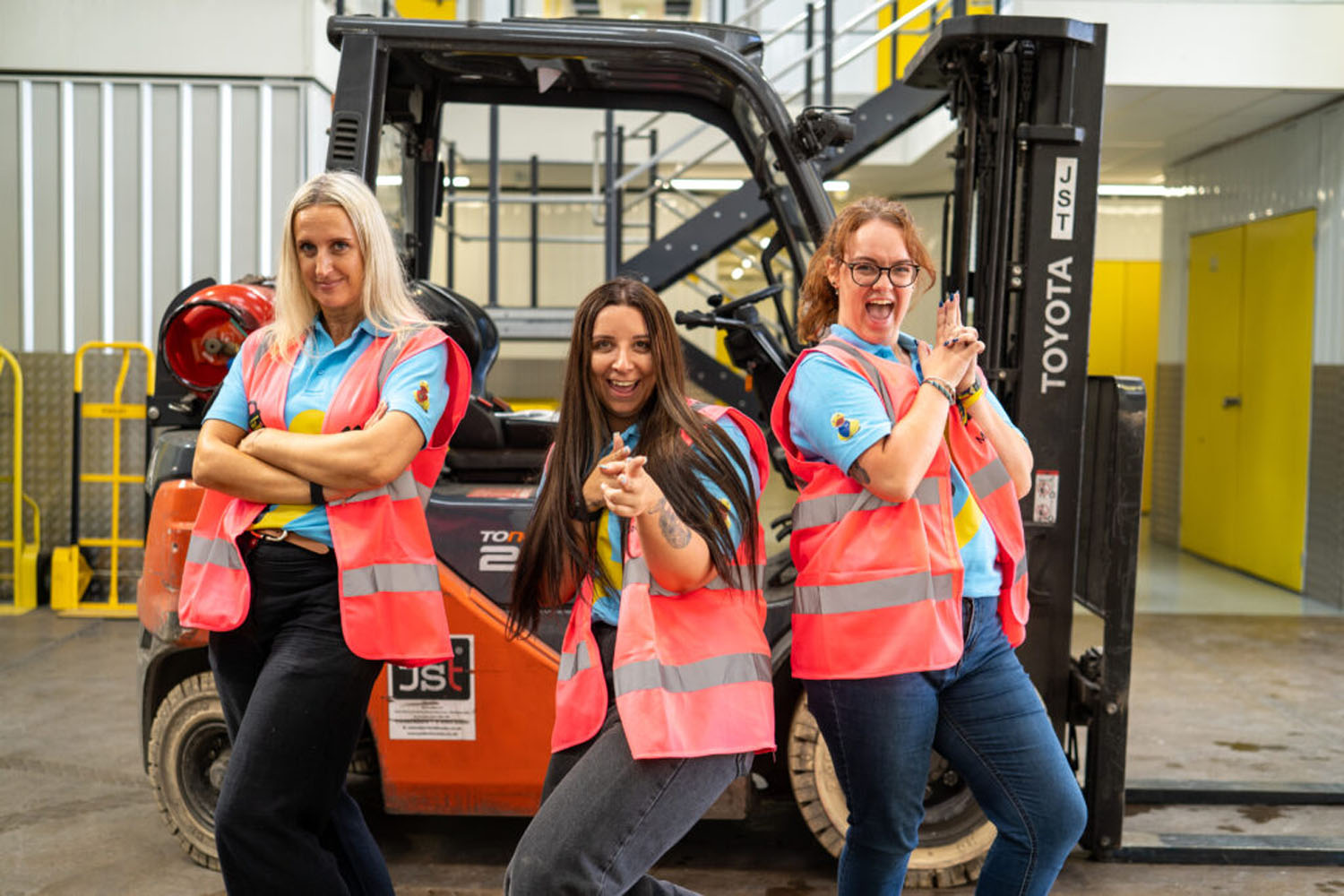 Storage team in hi-vis vests in front of a forklift truck