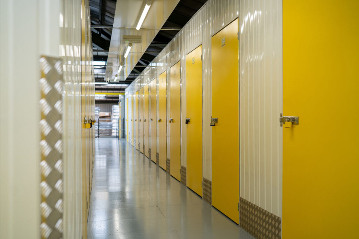 Corridor of yellow indoor storage unit doors