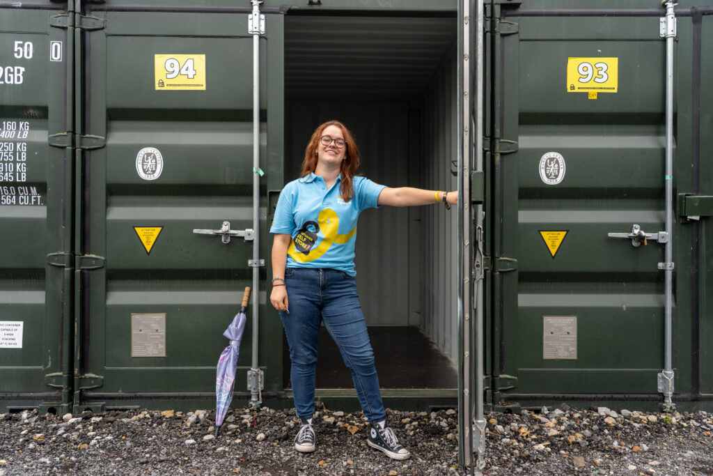 Team member standing in the doorway of an open green storage container