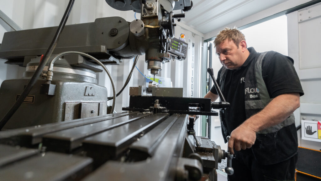 Engineer operating a milling machine inside a workshop unit